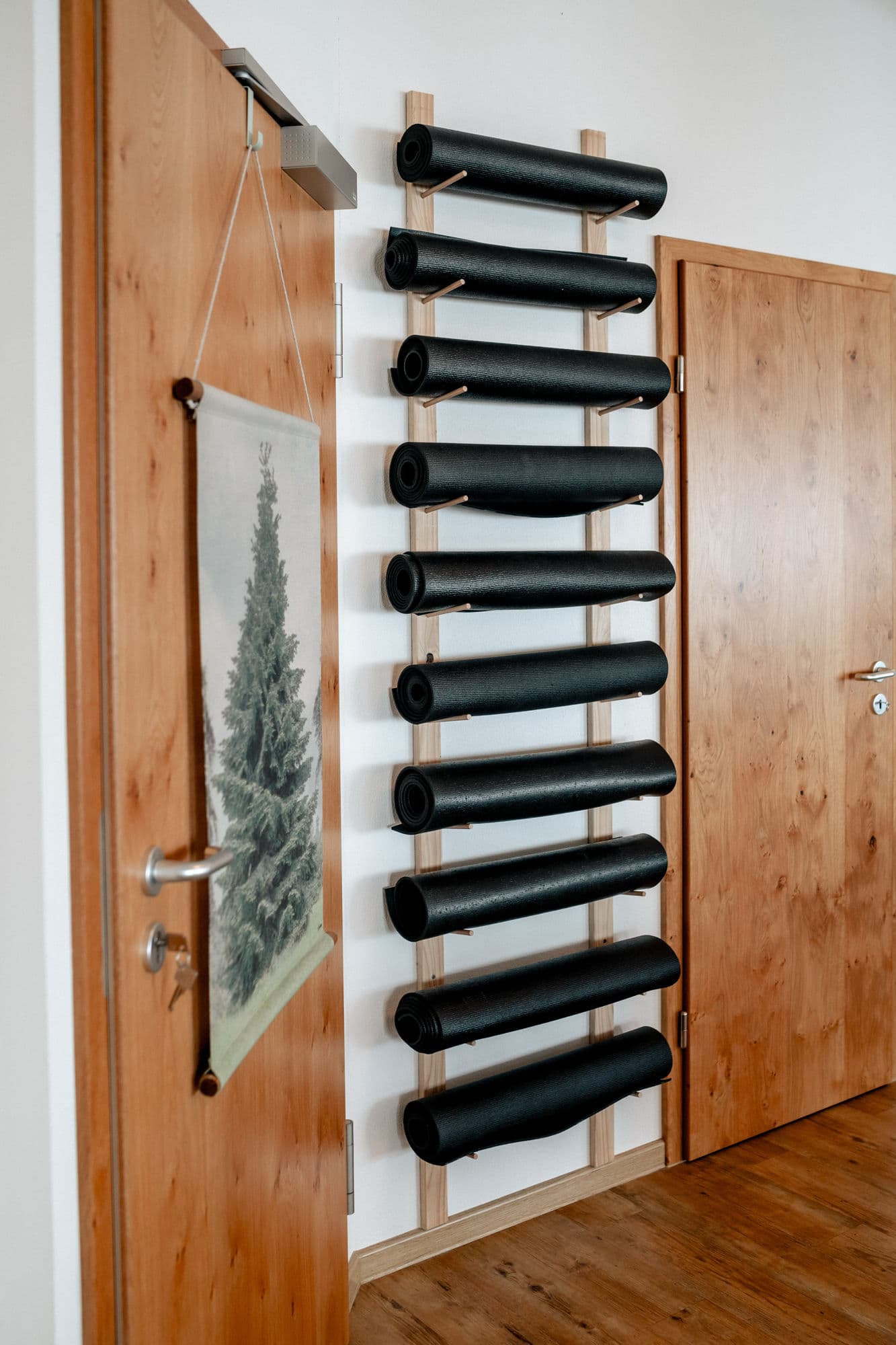 Wandhalterung mit Yogamatten neben einem Naturbild